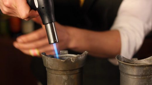 Waarom steekt een bartender een cocktail in de fik? Bartenders zetten soms opzettelijk cocktails in de brand. Maar waarom gaat de fik in de cocktail?